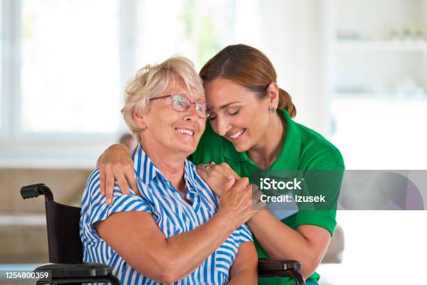 Female Social Worker Supporting Senior Woman Stock Photo - Download Image Now - Embracing, Community Outreach, Healthcare Worker