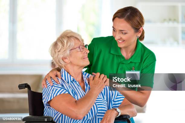 Female Social Worker Supporting Senior Woman Stock Photo - Download Image Now - Assisted Living, Domestic Life, Community Outreach