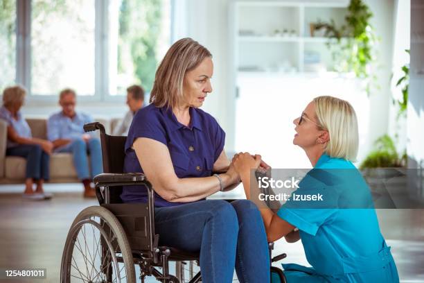 Friendly Nurse Consoling Senior Woman Stock Photo - Download Image Now - 70-79 Years, A Helping Hand, Adult