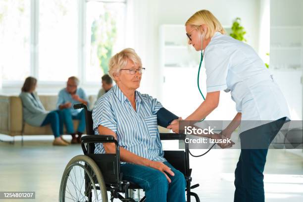 Home Nurse Checking The Blood Pressure Of The Elderly Lady Stock Photo - Download Image Now