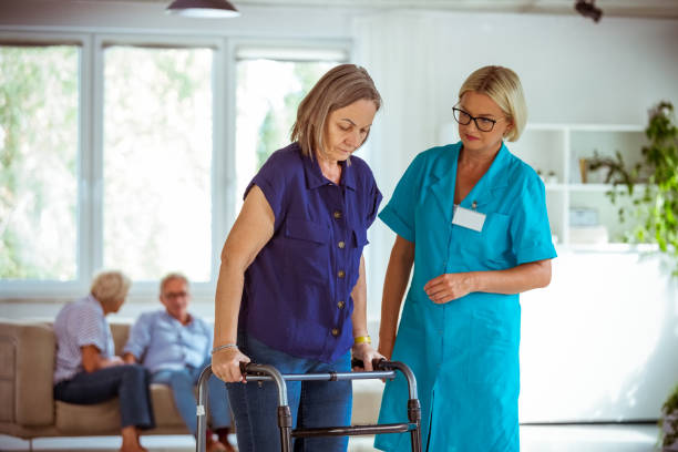 istock Nurse helping senior woman to use walking frame 1254801511