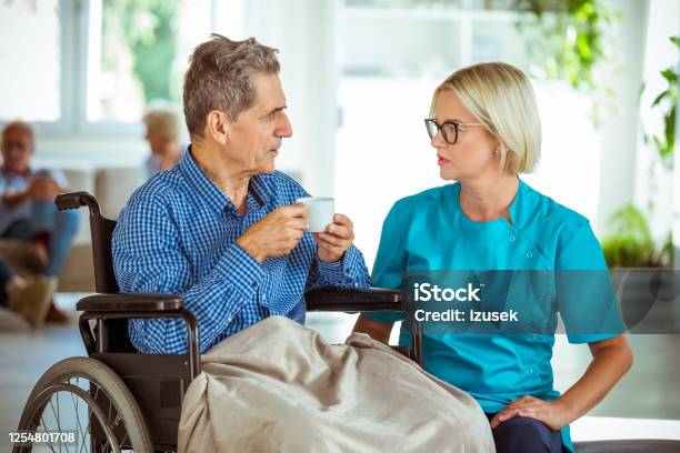 Nurse Talking With Senior Man In Retirement House Stock Photo - Download Image Now - 70-79 Years, Adult, Aging Process