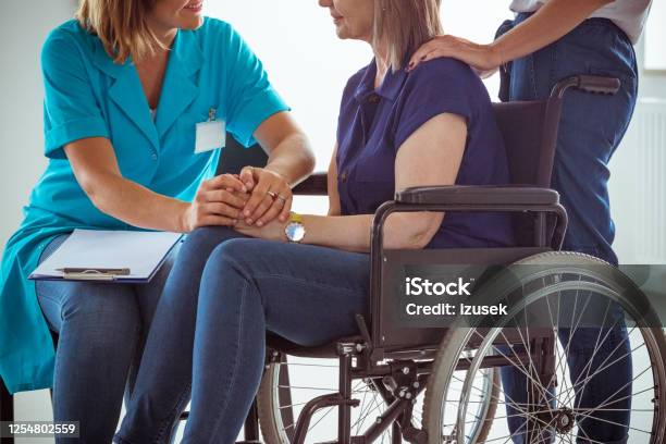 Nurse Talking With Worried Senior Woman In Hospital Waiting Room Stock Photo - Download Image Now