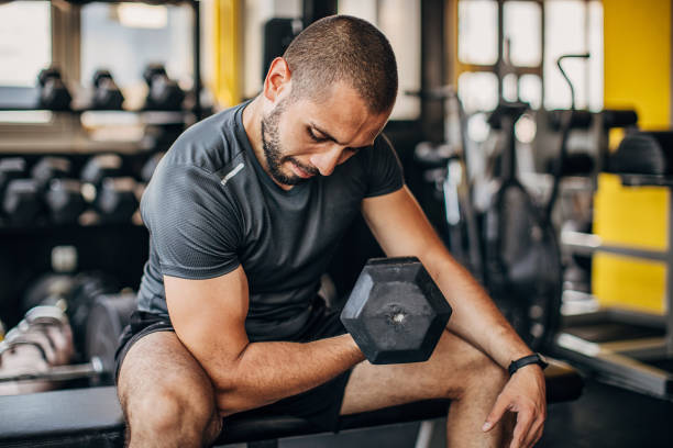 istock One male athlete training with dumbbells in the gym 1254803049