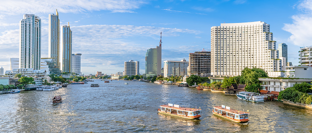 Bangkok city center financial business district, waterfront cityscape and Chao Phraya River during sunny day, panorama