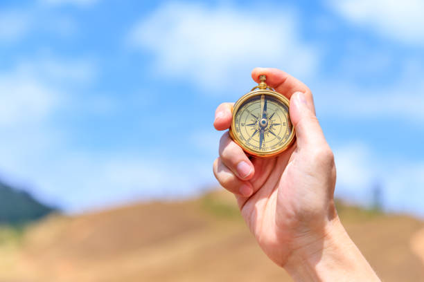 istock Compass in male traveler man hand in meadow 1254804475
