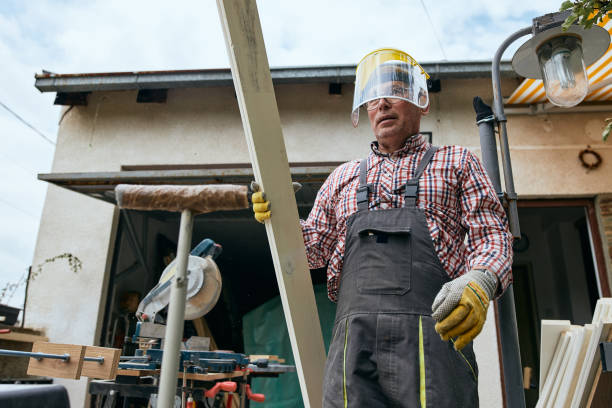 istock Lumberjack cutting planks with a circular saw in his backyard 1254804520