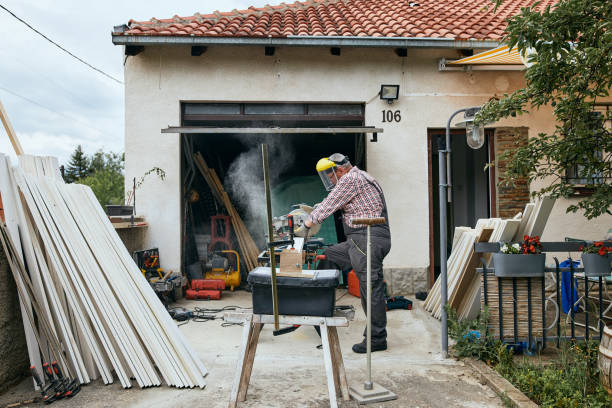 Senior adult man cutting wood outdoors in his small home backyard workshop