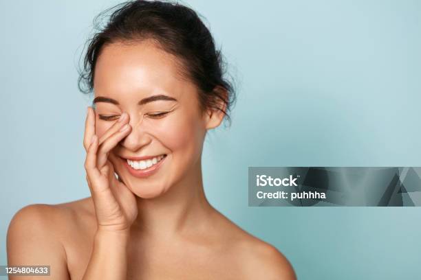 Cara De Belleza Sonriente Mujer Asiática Tocando Retrato De Piel Saludable Foto de stock y más banco de imágenes de Mujeres