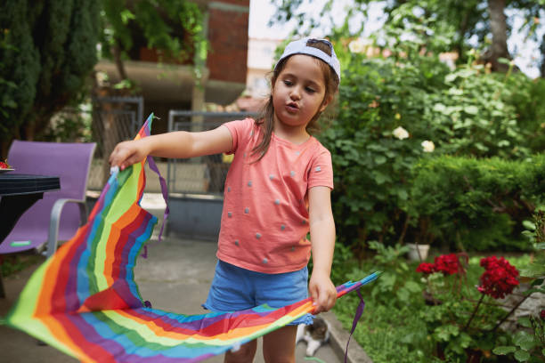 istock Little girl whistling while playing around with her kite 1254805186