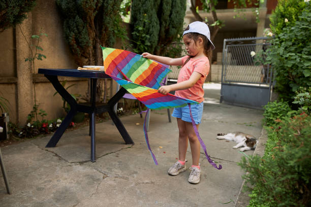 istock Pretty little girl playing with her rainbow kite 1254805200