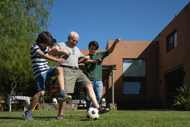 istock Skilled grandfather dribbling around his grandsons 1254805600