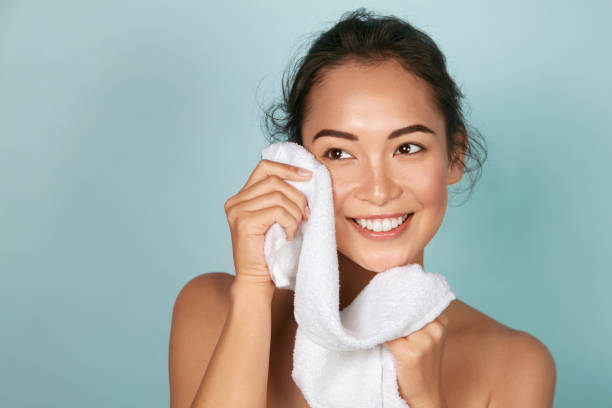 lavare il viso. primo piano della donna che pulisce la pelle con il ritratto dell'asciugamano - lavarsi il viso foto e immagini stock