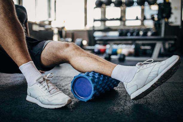 athlete using a foam roller - men exercising equipment relaxation exercise imagens e fotografias de stock