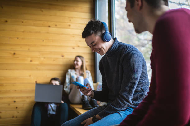 istock Happy university students listening to music and talking 1254805896