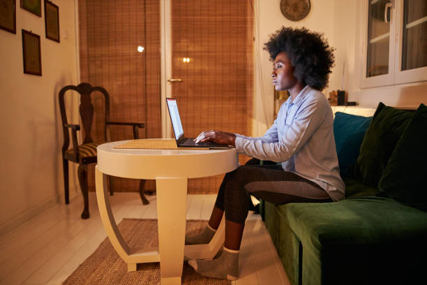 istock Side view of a woman working from home at night 1254808455