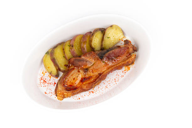 Image of a dish with roasted pork and sweet potato isolated on white background