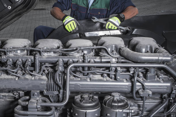 Young technician repairing car engine in car service