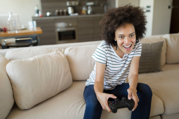 istock Excited young woman playing video games 1254812391