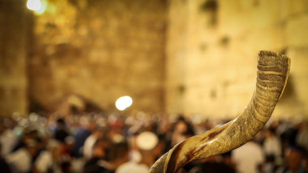 shofar y en el fondo, los religiosos oran en el muro de las lamentaciones en la ciudad santa de jerusalén en israel - yom kippur fotografías e imágenes de stock