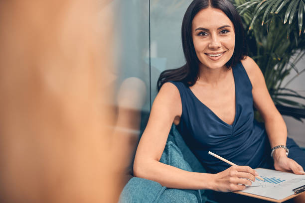 istock Smiling Caucasian businesswoman posing at the camera while working above task 1254817410