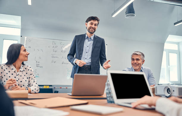 istock Bearded office worker wearing business suit standing at the board room 1254817552
