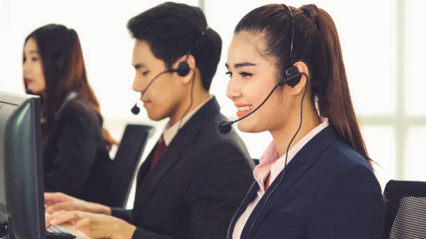 istock Business people wearing headset working in office 1254818359