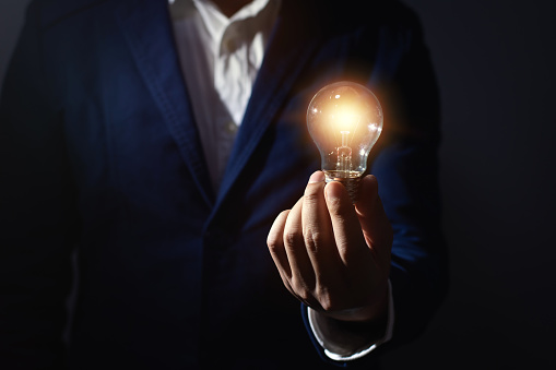 businessman hand holding light bulb for innovation and creative idea concept.