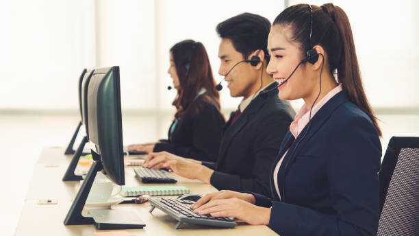 istock Business people wearing headset working in office 1254819120