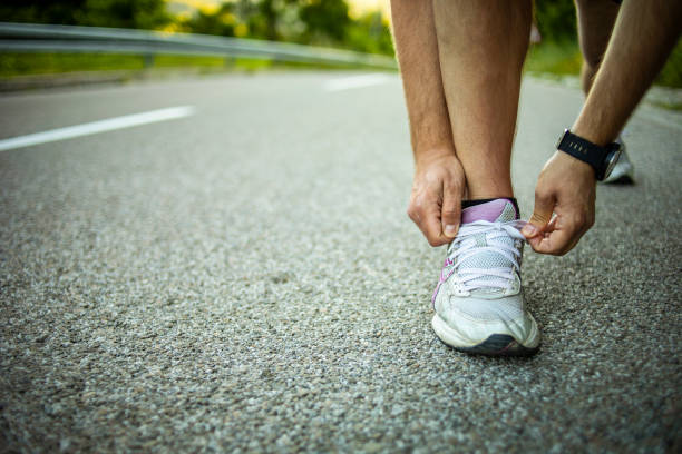 istock An athletic man performs an exercise from running on the street in a national park - Afternoon sports activities 1254820748