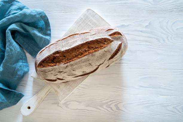 istock Wholegrain rye bread loaf on white wooden background 1254822258