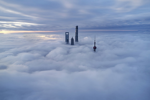 Aerial view of Shanghai skyline on thick cloud at morning, China.
