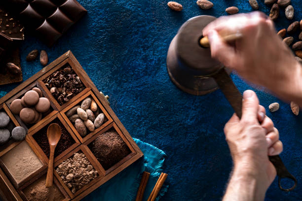 istock Chocolate pot copper grinding cocoa with hands holding stick with assorted chocolate box 1254822604