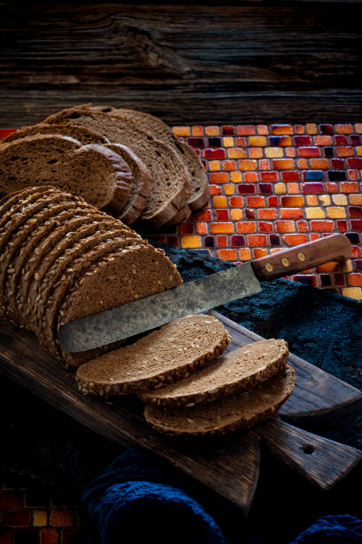 Wholegrain rye bread loaf on cutting board with vintage knife