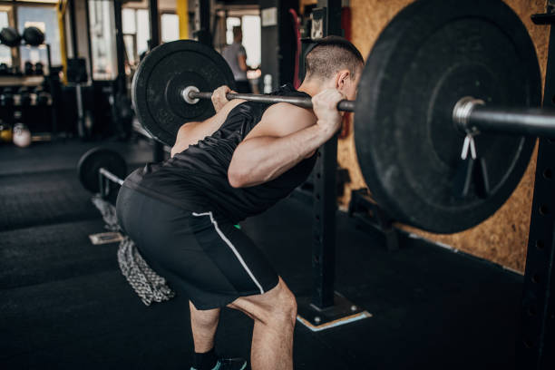 istock Man exercising with weights in gym 1254826303
