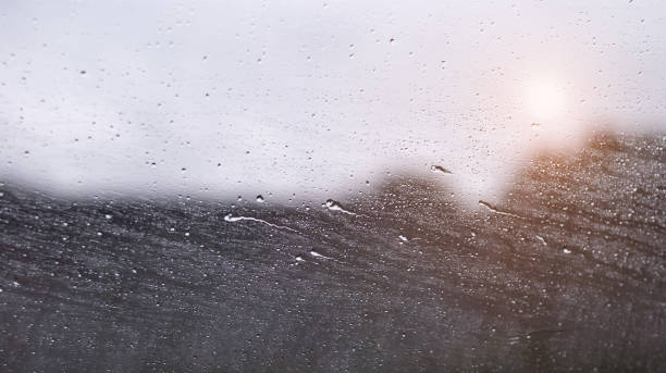 istock Drops and horizontal drips of rain on a car window 1254829321