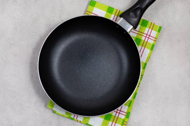 istock Empty black frying pan with green kitchen towel 1254829630