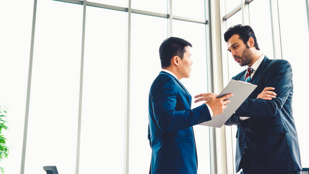 istock Two business people talk project strategy at office 1254831716
