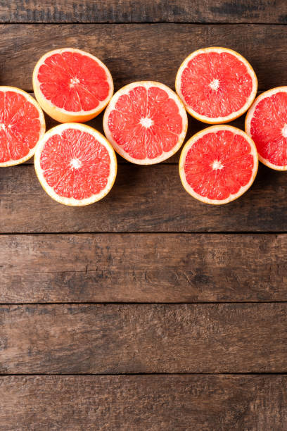 istock Fresh grapefruits on wooden background with copyspace 1254833491