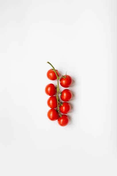 istock Sprig of ripe fresh cherry tomato on a white background, top view, flat lay 1254835709