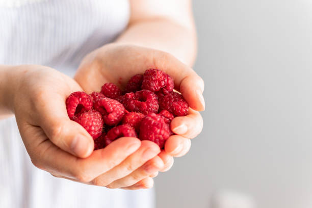 istock Hand with red raspberries.Raspberries in the hand. 1254835769