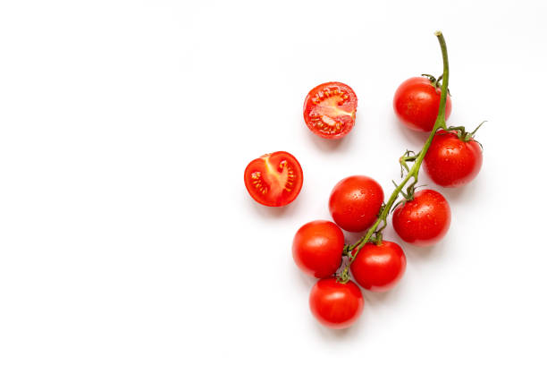 Fresh cherry tomatoes on a branch isolated on a white background. View from above Fresh cherry tomatoes on branch isolated on a white background, flat lay tomato photos stock pictures, royalty-free photos & images