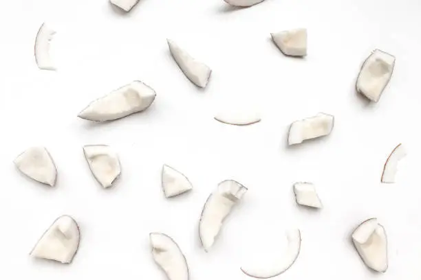 Raw coconut pieces pattern on a white background