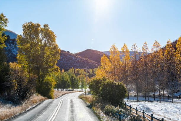 cidade pequena de aspen, colorado eua com rua de estrada vazia durante o nascer do sol da manhã do outono com folhagens douradas amarelas no bairro de woody creek - tranquil scene sky street road - fotografias e filmes do acervo