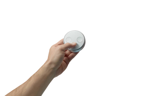 istock Man hand holding a smart home automation remote control on white background (Clipping Path) 1254838893
