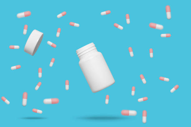 istock Red and white medicine pills floating around open bottle 1254840526