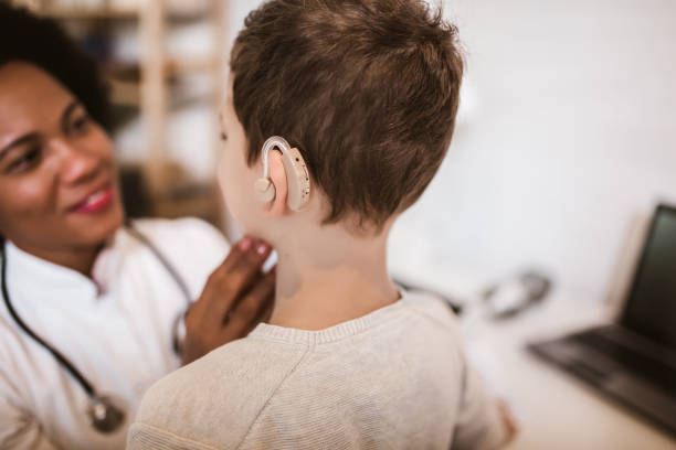 istock Smiling deaf boy with ear implant at doctor's office. 1254844021