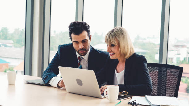 istock Two business people talk project strategy at office 1254844098