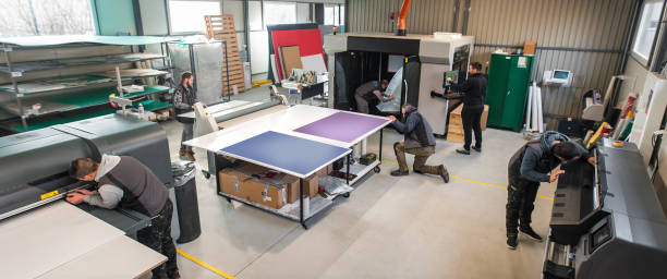 Large group of technicians works in printing printshop press hall