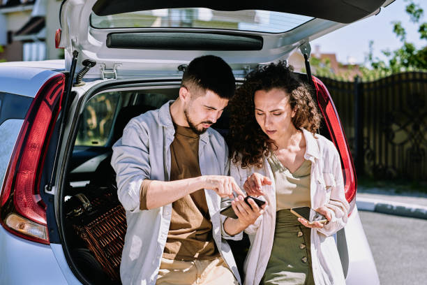 istock Young man pointing at mobile map while explaining his wife where they are going 1254844438